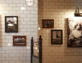 Wall covered in subway tiles and framed vintage photographs