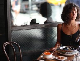 Photo of woman eating mussels at a table
