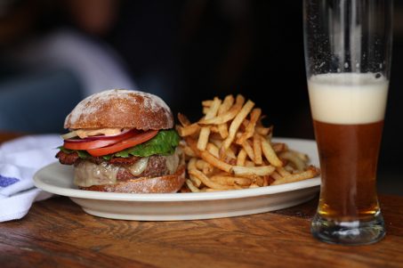 Burger and fries next to a glass of beer