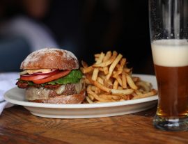 Burger and fries next to a glass of beer