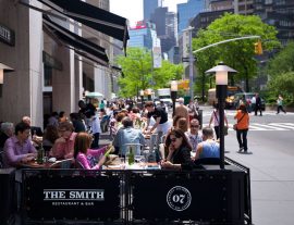 Exterior photo of The Smith Lincoln Square outdoor cafe filled with guests