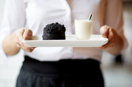 Staff member holding plate with dessert