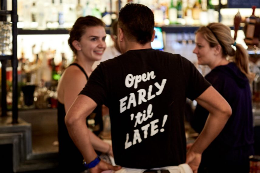 Photo of staff wearing a shirt that says 'Open Early 'til Late!'